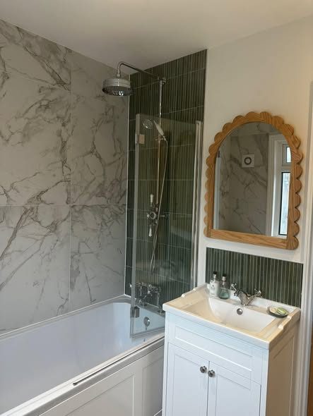 Bathroom refit with marble panelling, green tiling and a white vanity unit