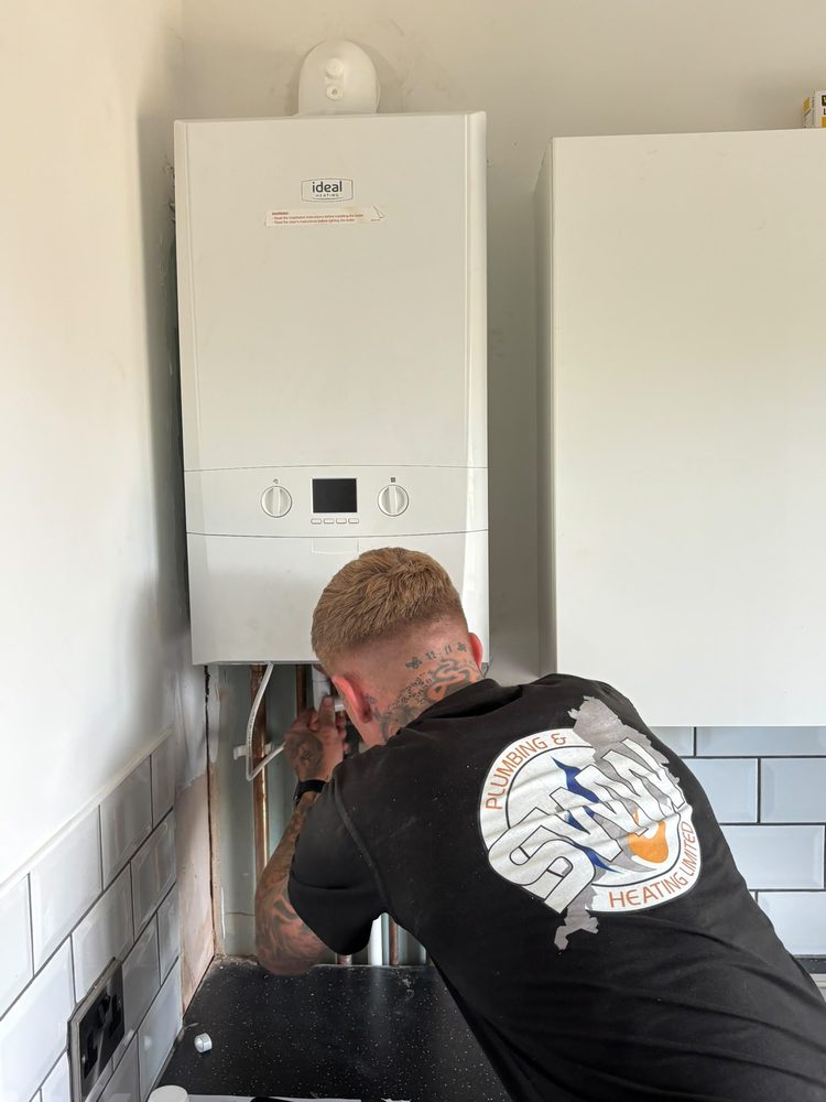 SWW engineer connecting pipework on a new boiler in Exeter